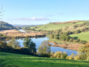 A scenic view of the Devon River Dart flowing gently through a picturesque landscape.